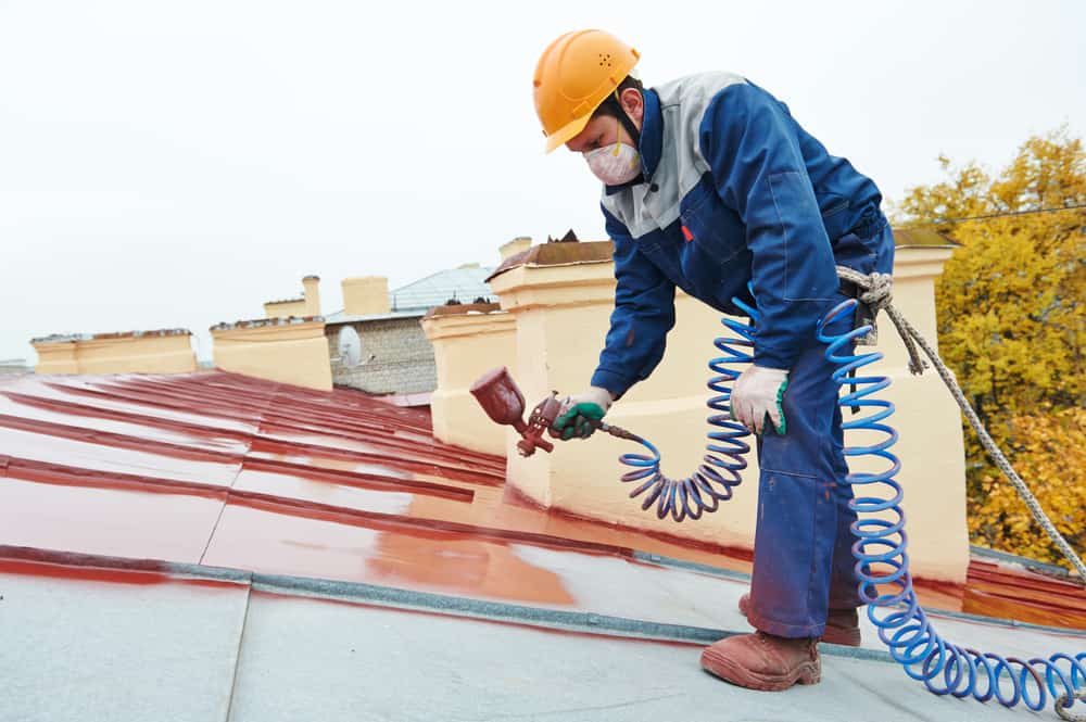Roofer Builder Worker With Pulverizer Spraying Paint On Metal Sheet